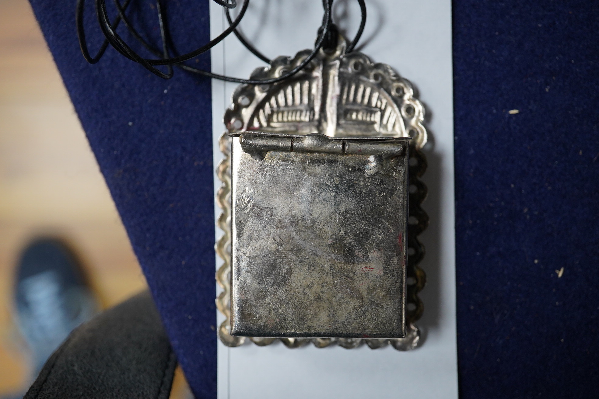 A Grayson Perry reliquary white metal pendant containing a section of tile, with Tate box, 7.5cm high. Condition - good